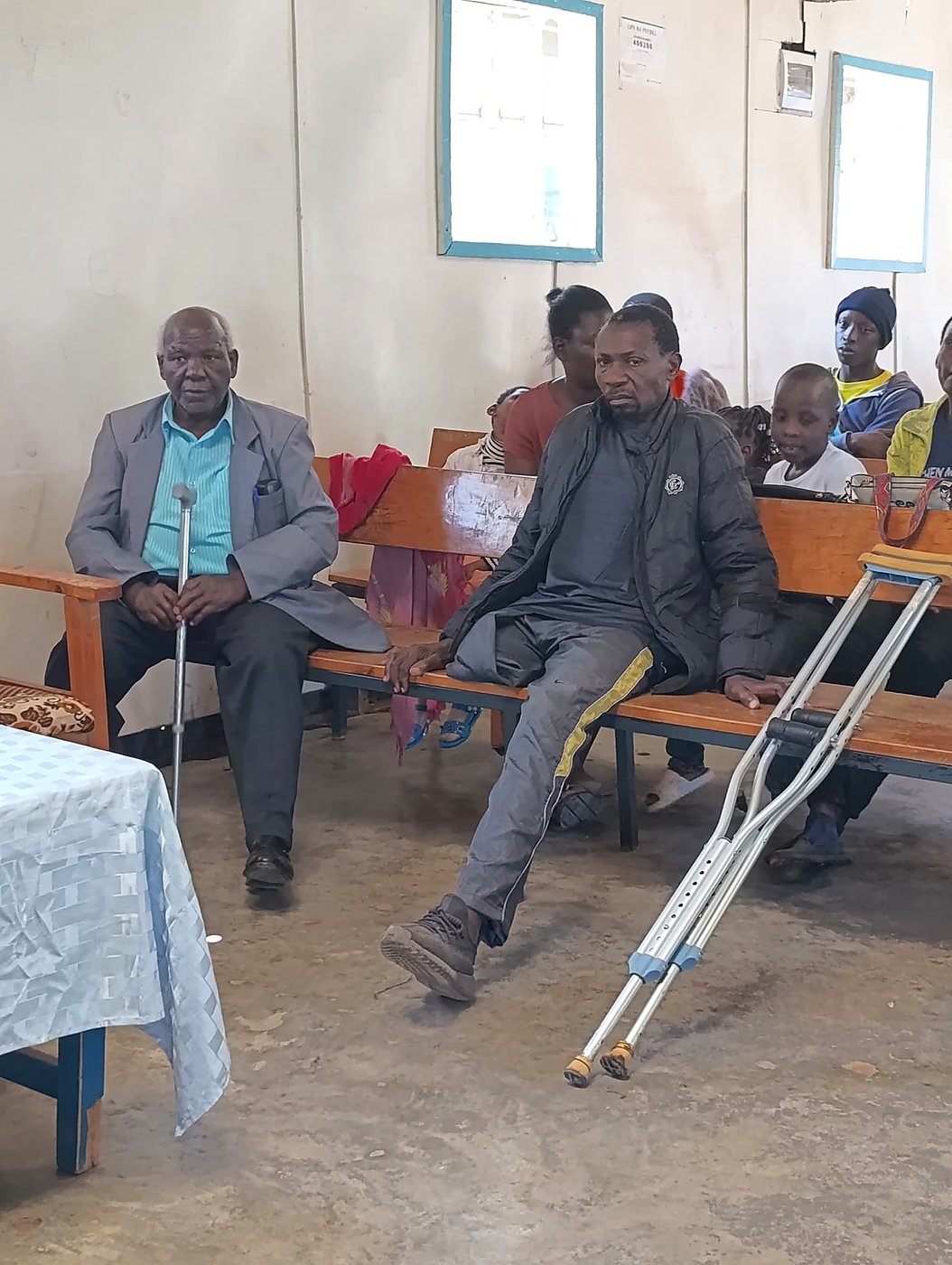 Community members, including people using crutches, at a GCIG meeting